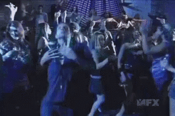 a man in a blue shirt is dancing in front of a group of people with avfx written on the bottom