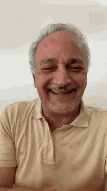 a man with gray hair and a beard is smiling