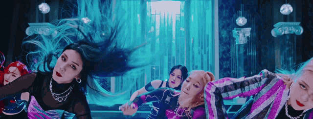 a group of women are dancing in a room with blue lights behind them