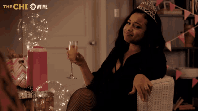 a woman wearing a tiara and holding a glass of wine with the showtime logo behind her