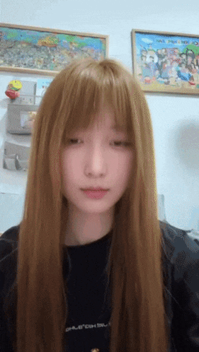 a girl with long blonde hair is wearing a black shirt that says " oalercom "