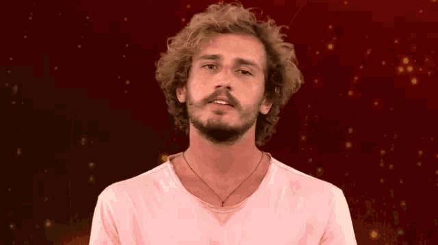 a man with a beard wearing a pink shirt