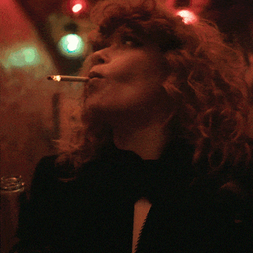 a woman with red hair smoking a cigarette