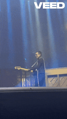 a man playing a guitar on a stage with the word veed on the bottom