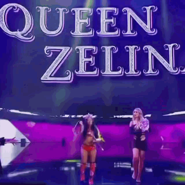 a woman in a crown is holding a trophy on a stage while another woman stands behind her .