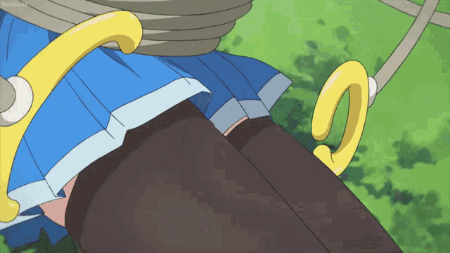 a girl in a blue skirt is tied to a yellow rope swing