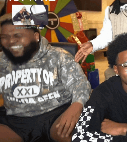 a man wearing a property of xxl sweatshirt smiles