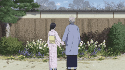 a man and a woman holding hands in front of a fence