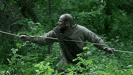 a man is holding a rope in the woods .