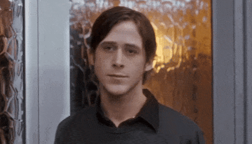 a young man in a black shirt stands in front of a door