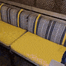 a bench with yellow cushions and blue and white stripes on it