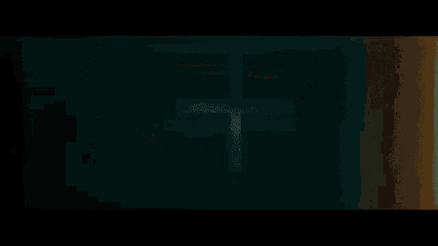 a cross is visible in the dark against a green background