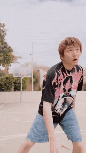 a young man wearing a t-shirt with a skull on it is playing basketball