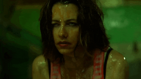 a close up of a woman 's face with sweat coming out of her face .