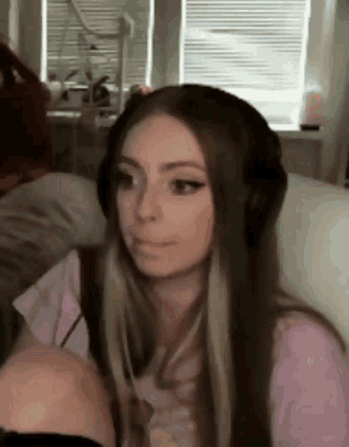 a woman wearing headphones is sitting on a couch in a living room .