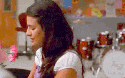 a woman is sitting in front of a drum set and a sign that says ' i love you ' on it