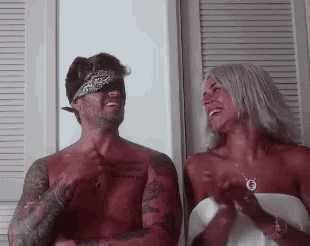 a man and a woman are sitting next to each other in a room .