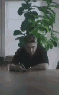 a man is sitting at a table in front of a laptop computer .