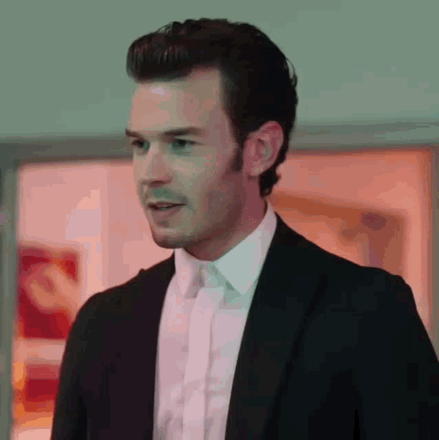 a man in a suit and white shirt is looking at something