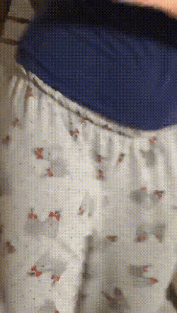 a person is wearing a pair of white pajama pants with a blue collar