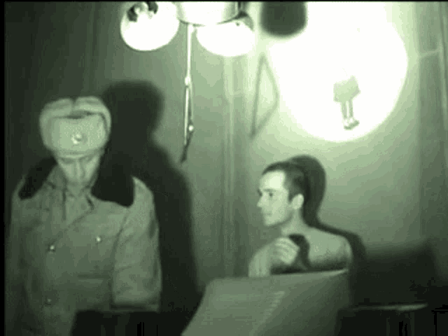 a man in a military uniform is standing next to another man in a room