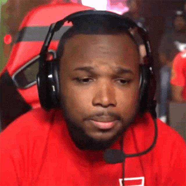 a man wearing headphones and a red shirt with a d on it