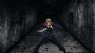 a man in a red hoodie is holding a knife in his hand in a dark room .