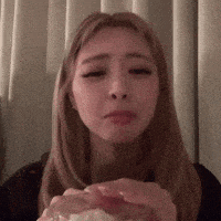 a woman is holding a piece of cake in her hands .