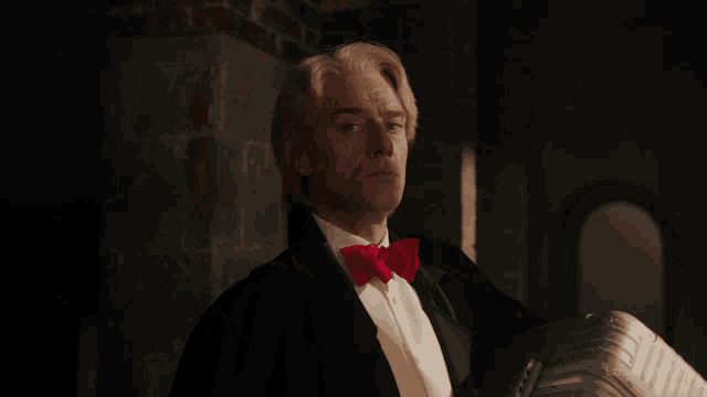 a man in a tuxedo with a red bow tie and the words lostfilm.tv on the bottom