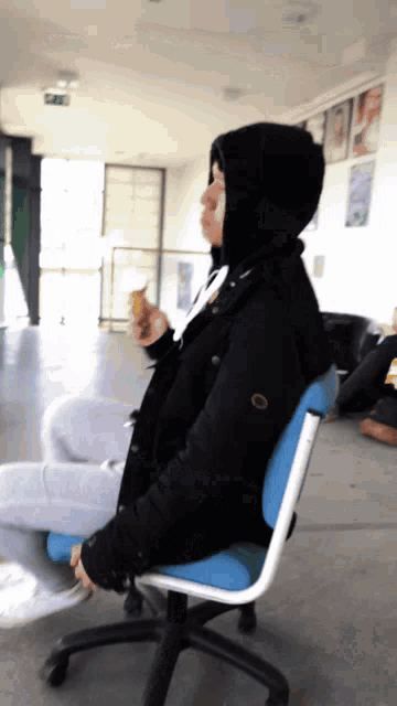 a person in a black jacket is sitting in a chair