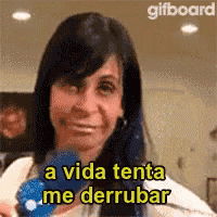 a woman is smiling and holding a blue object with the words a vida tenta me derrubar written on it