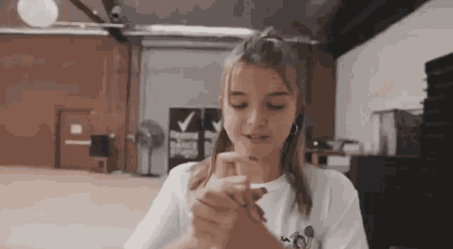 a young girl is making a heart shape with her hands in a dance studio .