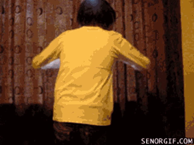 a person in a yellow shirt is dancing in front of a curtain with senorgif.com at the bottom of the screen