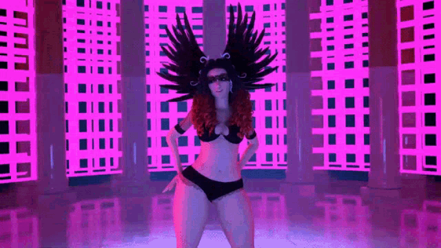 a woman in a black bikini is dancing in front of a pink wall