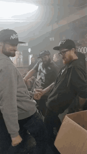 a man wearing a hat that says nas on it talks to another man