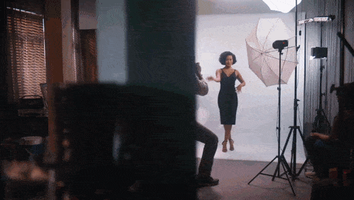 a woman in a black dress is being photographed