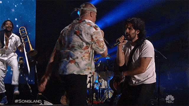 a man singing into a microphone in front of a screen that says songland