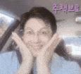 a woman in a car with her hands on her face .