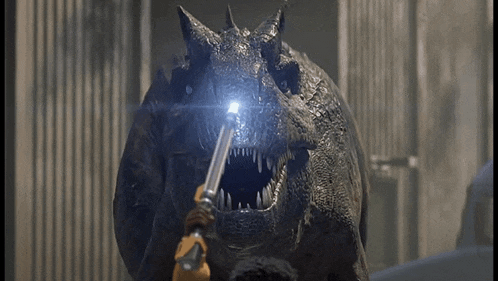 a person is holding a torch in front of a dinosaur