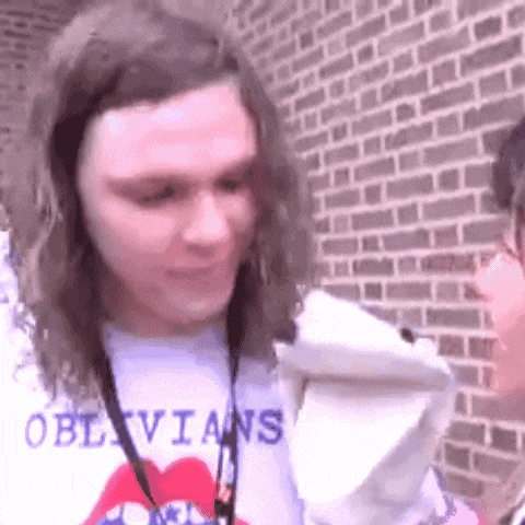 a man with long hair is wearing a shirt that says oblivians on it