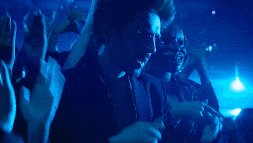a crowd of people applauding in a blue light