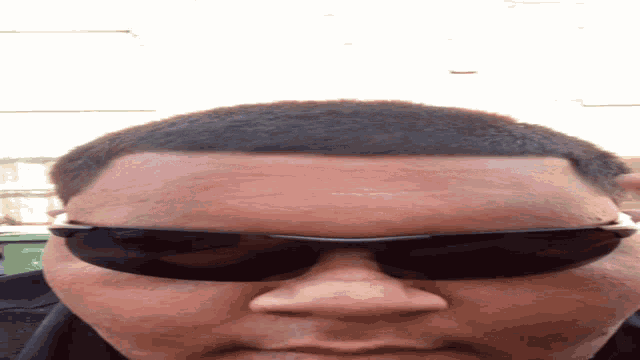 a close up of a man wearing sunglasses