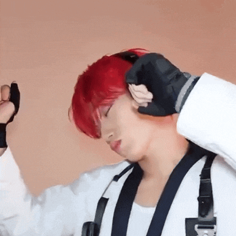 a man with red hair is wearing black gloves and a white shirt .
