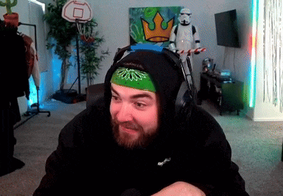 a man wearing headphones and a bandana is sitting in front of a storm trooper and a basketball hoop .
