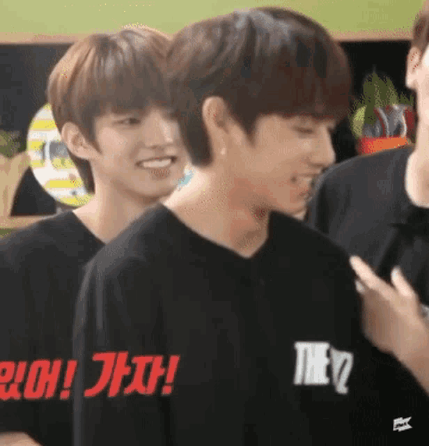 a man wearing a black shirt that says they is smiling