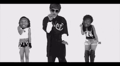 a black and white photo of a man and two women dancing .