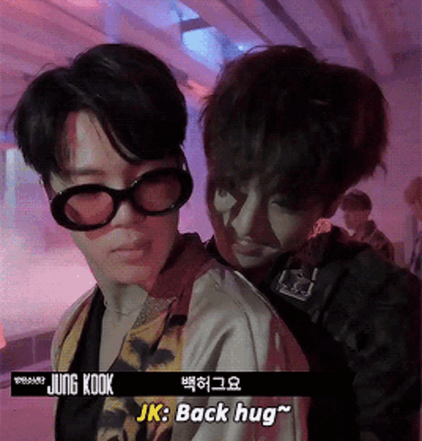 a man wearing sunglasses is hugging another man with the words jung kook jk back hug on the bottom