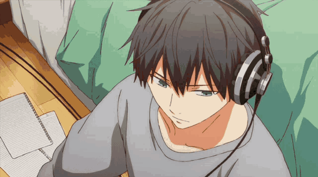 a man wearing headphones sits on a bed