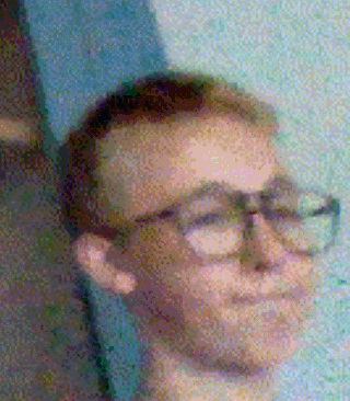 a close up of a man 's face with glasses