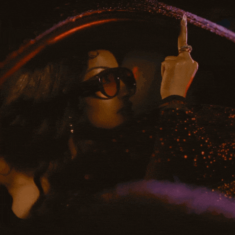 a woman wearing sunglasses giving the middle finger